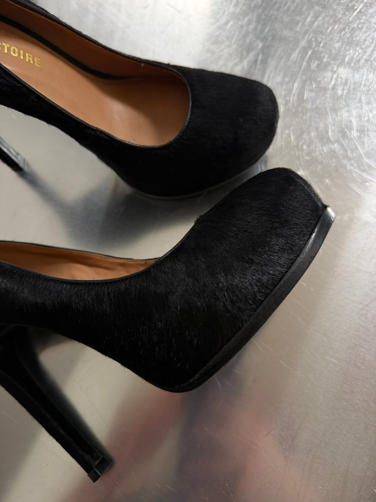 Black leather heels with a sleek, elegant silhouette.